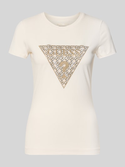 Produktfoto, Slim Fit T-Shirt aus Baumwoll-Mix mit Logo-Print von GUESS in Creme mit goldfarbenen Ziersteinen und Rundhalsausschnitt.
