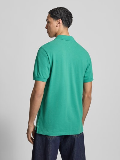 Mannelijk model draagt Regular Fit Poloshirt uit puur katoen van Tommy Jeans, look: effen, logostitching, piqué, korte mouw, rompzoom met zijsplitten, geheel in achteraanzicht.