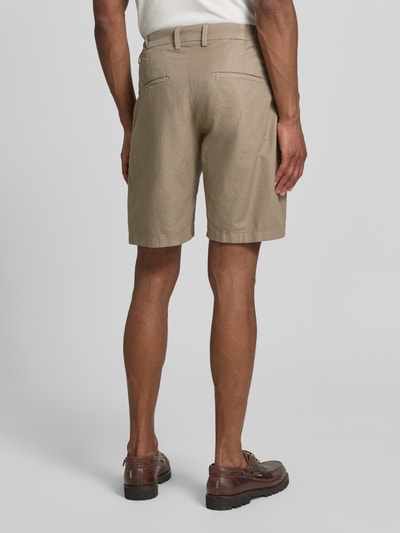 Männermodel trägt Shorts mit Gesäßtaschen Modell 'YASAN' von Drykorn, Leinen-Baumwoll-Mix, Regular-Fit, Beige, Ganzkörperansicht Rückansicht.