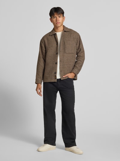 Männermodel trägt Regular Fit Hemdjacke mit Brusttasche Modell 'SOHO OLLIE' von JACK & JONES, braunes Karo, Ganzkörperansicht von vorne. Kontext: Herren Hemdjacke, Kentkragen, durchgehende Knopfleiste, Rückenlänge 71 cm, Schulterbreite 41 cm, Ärmellänge 65 cm.