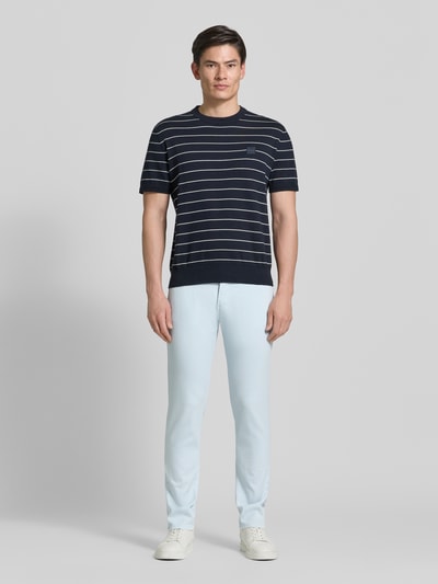 Männermodel trägt Regular Fit Hose mit Eingrifftaschen Modell 'Lyon' von Pierre Cardin aus Baumwoll-Elasthan-Mix, Ganzkörperansicht von vorne.