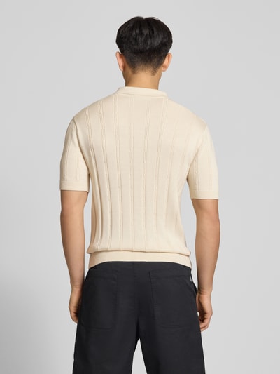 Männermodel trägt Slim Fit Strick-Poloshirt mit Label-Stitching von REVIEW in Creme mit Zopfmuster, Reine Baumwolle, Rückenlänge 67 cm, Ganzkörperansicht Rückansicht.