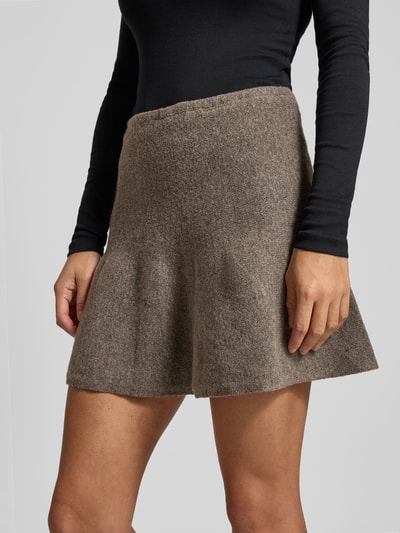 Frauenmodel trägt Minirock mit elastischem Bund Modell 'SLOAN' von Noisy May in braun, lockerer Schnitt, Material-Mix mit Woll-Anteil, Nahaufnahme Oberkörper.