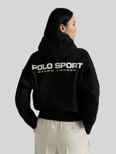 Vrouwenmodel draagt Relaxed Fit Hoodie aus Baumwoll-Mix van Polo Ralph Lauren in effen kleuren met labelopschrift en labelprint, sweat van katoenmix, kangoeroezak, capuchon met tunnelkoord, lange mouw, rompzoom en mouwboord geribd, unisex. Ganzkörperansicht Rückansicht.