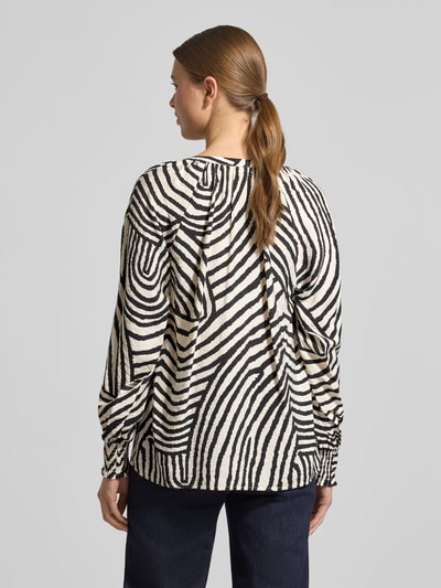 Frauenmodel trägt Hemdbluse mit Knopfleiste Modell 'BECCA' von Soyaconcept im Viskose-Mix, lockerer Schnitt, V-Ausschnitt, Rückenlänge 63 cm, Ärmellänge 72 cm, schwarz-weißes Streifenmuster, Ganzkörperansicht Rückansicht.