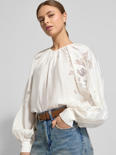 Frauenmodel trägt Langarmbluse aus Lyocell-Mix Modell 'MOLLY' von Copenhagen Muse in Weiß mit Satin, Ballonärmeln, floraler Spitze, lockerer Passform, Rundhalsausschnitt, Raffungen, Ganzkörperansicht von vorne.