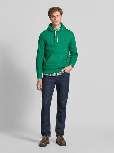 Mannelijk model draagt Regular fit hoodie van katoenmix van Polo Ralph Lauren in groen, met details in geel, jeans, Ganzlichaamsvooraanzicht.