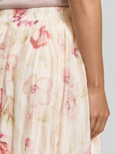 Frauenmodel trägt Midirock aus Lyocell-Mix Modell 'Ka44therine' von ZABAIONE im Allover-Look mit floralen Pastellfarben, Nahaufnahme Oberkörper. Bundweite bei Größe S: 36 cm, Gesamtlänge bei Größe S: 97 cm.