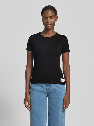 Frauenmodel trägt Armedangels Slim Fit T-Shirt aus Baumwoll-Mix Modell 'KARDAA' in Optik: Unifarben mit Logo-Stitching, Feinripp, Rundhals, Kurzarm, Ganzkörperansicht von vorne.