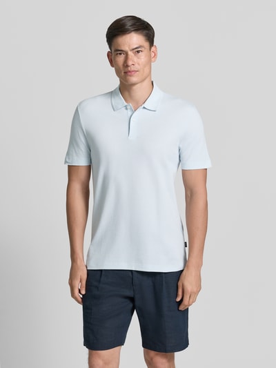 Męski model nosi Regular Fit Poloshirt aus Baumwoll-Mix Modell 'PARLAY 240' od BOSS, jednolity kolor, krój regular fit, krótki rękaw, bawełniana mieszanka, aplikacja z logo, kołnierzyk polo, dekolt w serek, zapięcie na 2 guziki. Ganzkörperansicht von vorne.
