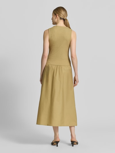 Frauenmodel trägt Midikleid mit U-Boot-Ausschnitt Modell 'VALVIN' von Mango in Beige, Baumwoll-Mix, taillierter Schnitt, Ganzkörperansicht Rückansicht.
