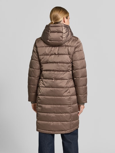 Vrouwenmodel draagt Regular Fit lange jas in stiksels van monari, capuchon met tunnelkoord, opstaande kraag, ruglengte maat 36: 100 cm, schouderbreedte 43 cm, borstwijdte 49 cm, mouwlengte 65 cm, steekzakken met ritssluiting, tweewegritssluiting, doorgestikte look, Ganzkörperansicht Rückansicht.