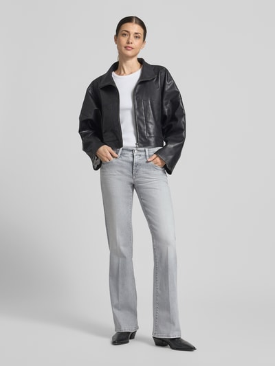 Modelka nosi Flared Fit Jeans aus Baumwoll-Mix von Cambio, jasnoszary dżins, krój flared fit, bawełna z elastanem, pięciokieszeniowy, zapięcie na guzik i zamek, szerokość w rozmiarze 36: 38 cm, długość nogawki wewnętrznej w rozmiarze 36: 83 cm, widok całej sylwetki z przodu.