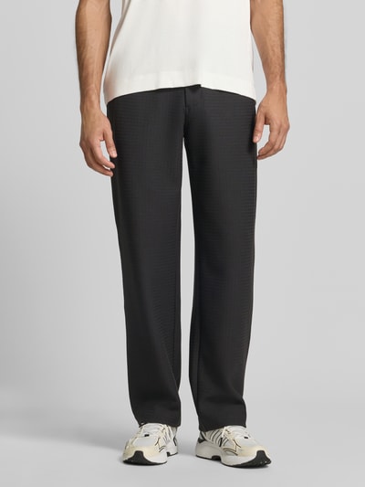 Männermodel trägt Wide Fit Sweatpants mit Lyocell-Anteil von Emporio Armani in Schwarz, elastischer Bund, Eingrifftaschen, Ganzkörperansicht von vorne.