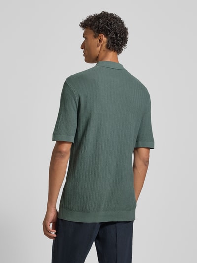 Męski model nosi Regular Fit Poloshirt aus reiner Bio-Baumwolle Modell 'CRAN' od SELECTED HOMME, strukturalny wzór, kolor zielony, widok całej sylwetki od tyłu.