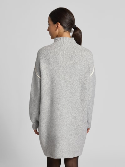 Frauenmodel trägt Regular Fit Strickkleid mit Kontraststreifen von VERO MODA, unifarben, Strickoptik, knielang, Mock Neck, Ganzkörperansicht Rückansicht.