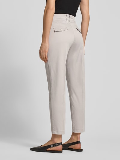 Frauenmodel trägt Hose in verkürzter Passform Modell 'Mara S' von Brax in Beige mit Bügelfalten und Eingrifftaschen, Ganzkörperansicht Rückansicht. Baumwoll-Mix mit Lyocell-Anteil, Bundweite 37 cm, Innenbeinlänge 67 cm bei Größe 36.