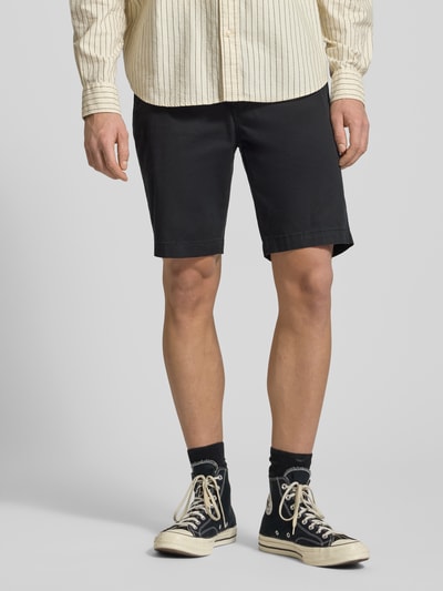 Männermodel trägt Regular Fit Chino Shorts aus Baumwoll-Mix von Levi's®, schwarze Farbe, Eingrifftaschen, Knopf- und Reißverschluss, Ganzkörperansicht von vorne.