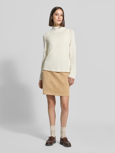 Frauenmodel trägt Regular Fit Mini-Rock in Cord-Optik von OPUS in Beige, kombiniert mit weißem Pullover, Ganzkörperansicht von vorne. Damen Mini-Rock.