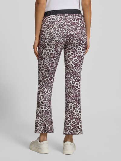 Frauenmodel trägt Flared Fit Stoffhose mit Allover-Animal-Print von Marc Cain, elastischer Bund, Stoff in Braun-Weiß, Ganzkörperansicht Rückansicht.