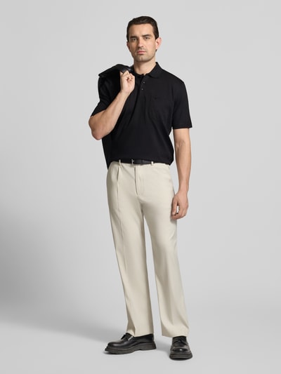 Męski model nosi Regular Fit Poloshirt mit Brusttasche od Christian Berg Men, czarny, z kołnierzykiem i kieszenią, krój regular fit, widok całej sylwetki z przodu.