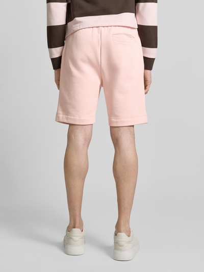 Mannenmodel draagt 'Regular Fit Sweatshorts aus Baumwoll-Mix' van Lacoste in effen lichtroze sweatstof met elastische tailleband, achteraanzicht, ganzlichaamsweergave rugaanzicht.
