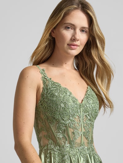 Frauenmodel trägt Regular Fit Abendkleid mit floralem Stitching von Luxuar in zartgrünem Satin, mit Ziersteinbesatz und Spaghetti-Trägern, semitransparentes Design, Nahaufnahme Oberkörper.