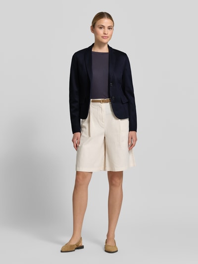 Frauenmodel trägt Slim Fit Blazer aus Viskose-Mix von Marc Cain in Dunkelblau mit Reverskragen, 2-Knopfverschluss, Pattentaschen, Ganzkörperansicht von vorne, Rückenlänge bei Größe 36: 56 cm, Brustweite bei Größe 36: 23 cm, Ärmellänge bei Größe 36: 63 cm.