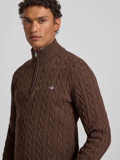 Männermodel trägt Strickpullover mit gerippten Abschlüssen von Gant in Braun, Reine Baumwolle, Slim-Fit, Stehkragen, Nahaufnahme Oberkörper.