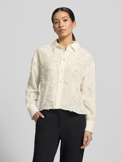 Frauenmodel trägt Boxy Fit Bluse im Allover-Look Modell 'Fenima' von OPUS in Creme mit strukturierter Oberfläche, Nahaufnahme Oberkörper. Rückenlänge 54 cm, Ärmellänge 53 cm, Hemdblusenkragen und Knopfleiste.