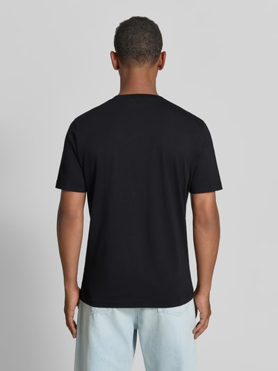 Männermodel trägt schwarzes Regular Fit T-Shirt aus reiner Baumwolle Modell 'JAAMES' von ARMEDANGELS, Ganzkörperansicht Rückansicht.