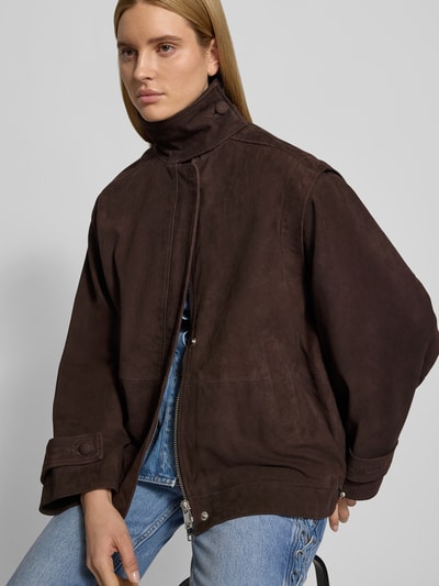Frauenmodel trägt Oversized Jacke mit Stehkragen von ROTATE aus Ziegenvelours, dunkelbraun, verdeckter Reißverschluss, Nahaufnahme Oberkörper.