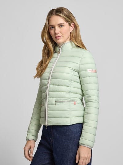 Frauenmodel trägt Steppjacke mit Reißverschlusstaschen Modell 'SISTER JUDY' von Frieda & Freddies, hellgrün, Ganzkörperansicht von vorne, Slim Fit, Stehkragen, sichtbare Struktur quer gesteppt, glatte Oberfläche, für Damen.