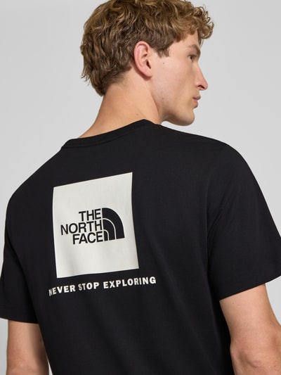 Mannenmodel draagt t-shirt met labelprint Model 'Evolution' van The North Face, katoenmix, regular fit, ruglengte maat M 73 cm, detailopname rugaanzicht.