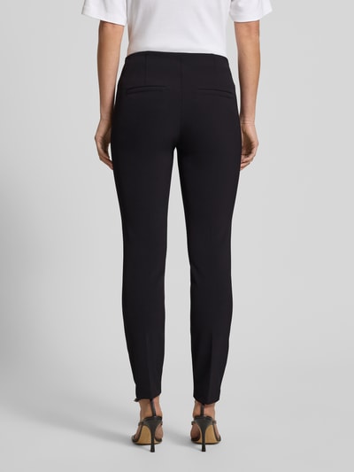 Modelka kobieca nosi Hose mit Längsnähten Modell 'ROS' od Cambio, czarne, wąski krój slim fit, skrócona długość, widok całej sylwetki z tyłu.
