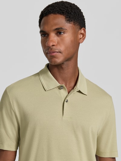 Männermodel trägt Regular Fit Poloshirt aus Baumwoll-Mix Modell 'PARLAY 240' von BOSS, unifarben, Label Patch, Nahaufnahme Oberkörper.