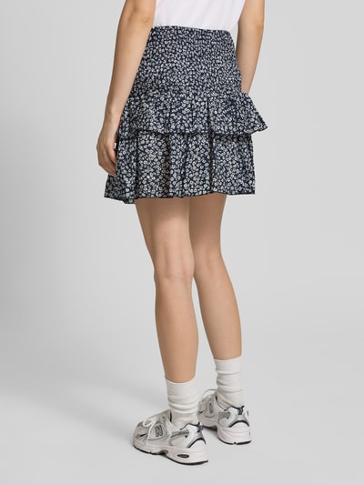 Frauenmodel trägt Ausgestellter Mini-Rock mit Volants Modell 'ZOEY' von Only, Florales-Allover-Muster, Regular-Fit, Volants, gesmokter Bundabschluss, reine Baumwolle, Mini-Länge, Ganzkörperansicht Rückansicht.