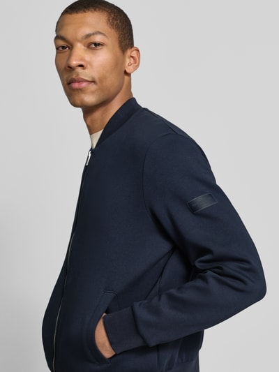 Männermodel trägt Regular Fit Bomberjacke aus Baumwoll-Mix von Marc O'Polo, Optik: Unifarben, Reißverschluss, Label-Patch, Nahaufnahme Oberkörper.