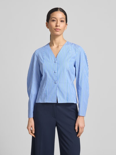Frauenmodel trägt Bluse mit V-Ausschnitt und Knopfleiste von Rich & Royal, reine Baumwolle, tailliert, hellblau mit Streifen, Ganzkörperansicht von vorne.