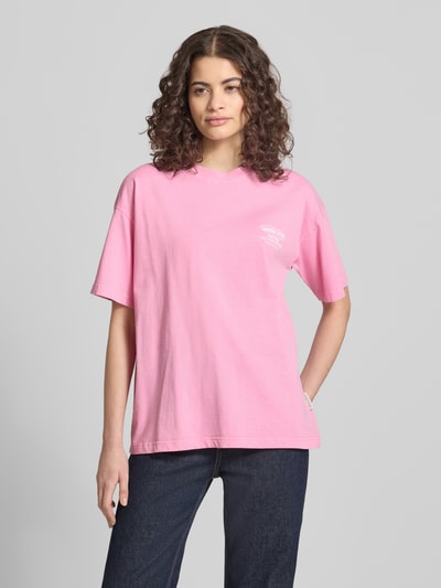 Frauenmodel trägt Oversized T-Shirt mit Logo-Print von ANOTHER COTTON LAB in Rosa, reine Baumwolle, Rundhalsausschnitt, Ganzkörperansicht von vorne.