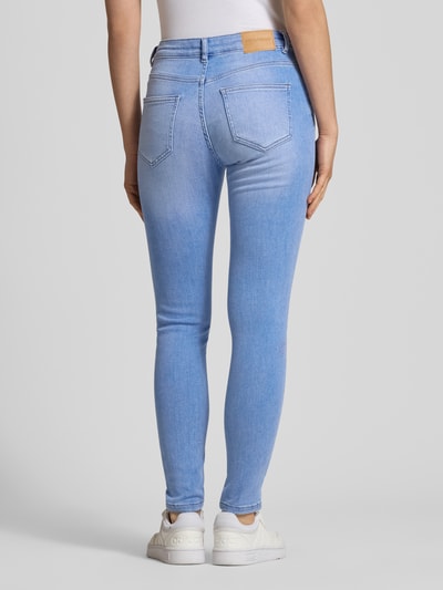 Vrouwenmodel draagt Skinny Jeans met middelhoog band in lichtblauwe wassing van Review, Mix van katoen en elastaan, skinny fit, 5-pocketmodel, knoop- en ritssluiting, bandwijdte maat 27: 35 cm, binnenbeenlengte maat 27: 71 cm, lichtblauw, achterkant volledig zichtbaar, Ganzkörperansicht Rückansicht.