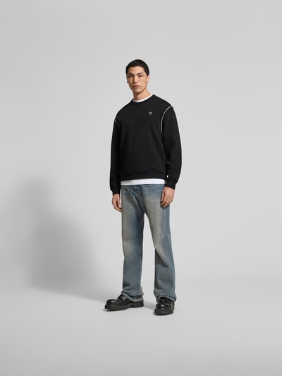 Männermodel trägt Sweatshirt aus reiner Baumwolle von Kenzo in Schwarz mit Label-Detail, lockerer Passform, Rundhalsausschnitt, elastische Abschlüsse, Rückenlänge bei Größe M 65 cm, Ganzkörperansicht von vorne.