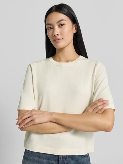 Frauenmodel trägt Boxy Fit Strickshirt aus Viskose-Mix Modell 'VMSILJE' von VERO MODA in Creme mit glatter Textur, Nahaufnahme Oberkörper.