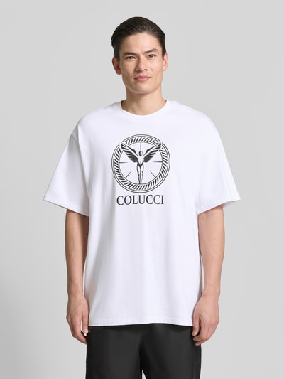 Männermodel trägt Herren T-Shirt mit Label-Print Modell 'IKARUS' von COLUCCI in Weiß aus reiner Baumwolle, Relaxed-Fit, Rundhalsausschnitt, Ganzkörperansicht von vorne.