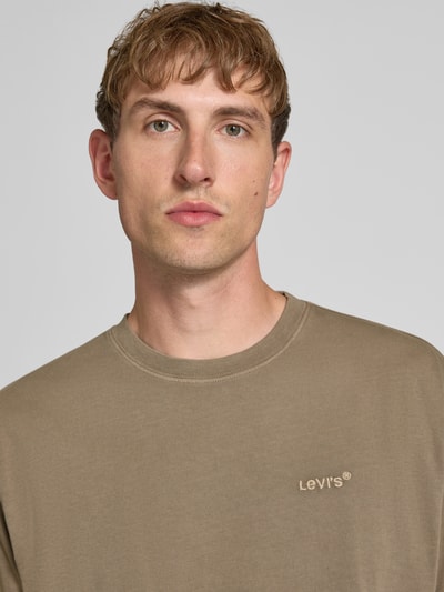 Männermodel trägt Relaxed Fit T-Shirt aus reiner Baumwolle Modell 'VINTAGE TEE' von Levi's®, Herren T-Shirt, beige, glatte Textur, Nahaufnahme Oberkörper.