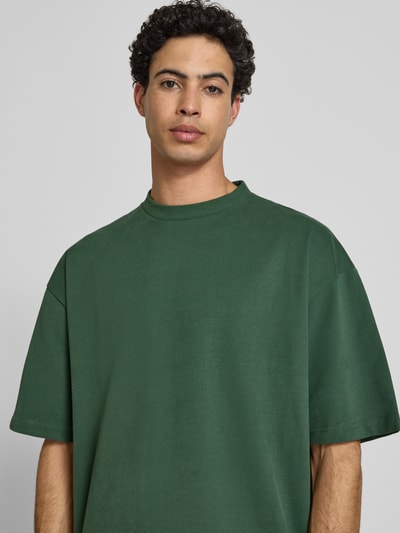 Männermodel trägt Oversized T-Shirt mit Rundhalsausschnitt von PROHIBITED aus Reine Baumwolle in Dunkelgrün, Nahaufnahme Oberkörper.