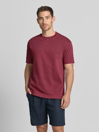 Männermodel trägt Relaxed Fit T-Shirt aus reiner Baumwolle von Marc O'Polo in Optik: Unifarben mit Label-Schriftzug, Passform: Relaxed-Fit, Rundhals, Ärmelform: Kurzarm, Materialverarbeitung: Jersey, Ganzkörperansicht von vorne.