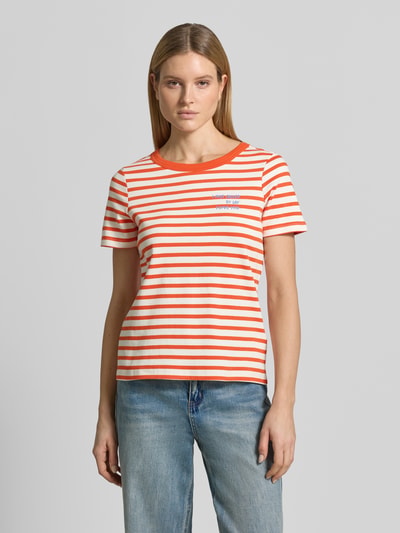 Frauenmodel trägt T-Shirt mit Rundhalsausschnitt und Stitching von Smith and Soul, orange-weiß gestreift, reine Baumwolle, Regular Fit, Ganzkörperansicht von vorne.