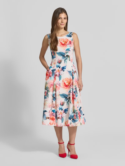 Frauenmodel trägt Cocktailkleid im Allover-Look mit gelegten Falten von Vera Mont, Material-Mix mit Stretch-Anteil, A-Linie, Midikleid, Rundhalsausschnitt, Mehrfarben mit floralen Mustern, glatte Textur, Ganzkörperansicht von vorne.