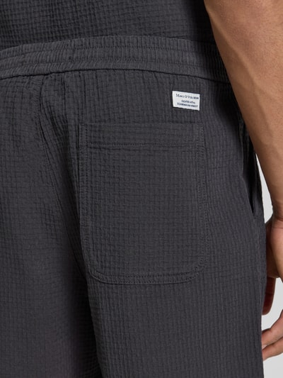 Männermodel trägt Regular Fit Sweatshorts aus reiner Baumwolle von Marc O'Polo Denim, Optik: Unifarben, Label-Patch, Materialverarbeitung: Piqué, Gesäßtasche, Nahaufnahme Oberschenkel.